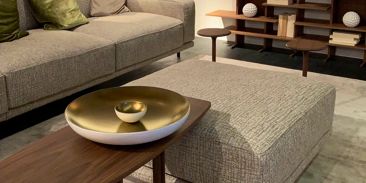 A cozy, well-styled living room with a tufted upholstered ottoman in the center