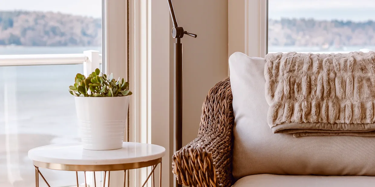 A modern floor lamp casting a warm glow beside a styled living room seating area