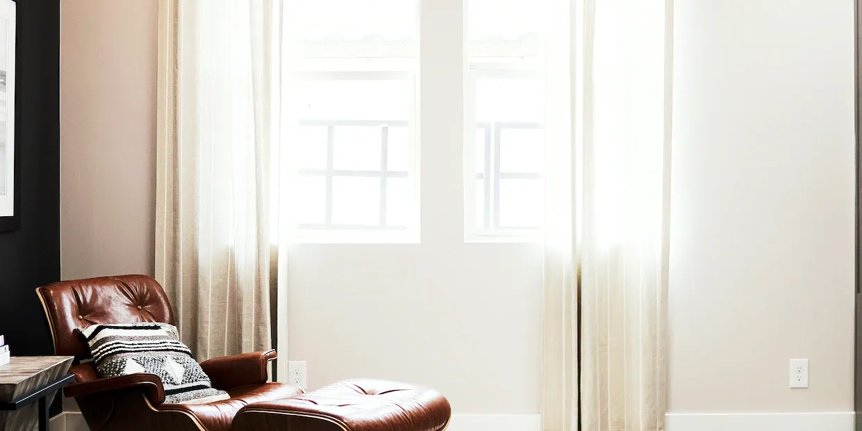 A bright, modern living room layered with a natural-fiber area rug